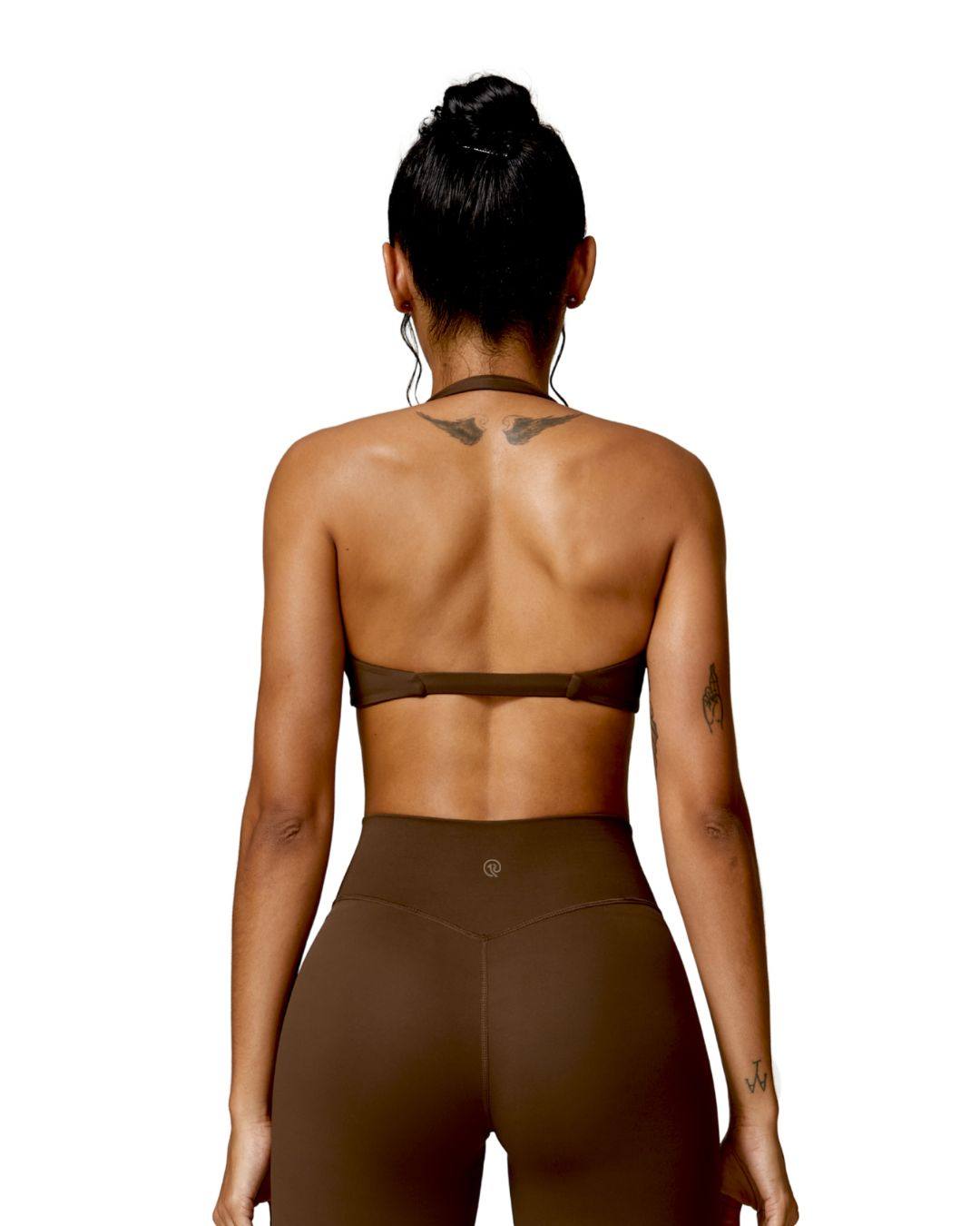 woman wearing brown oru mika halter sports bra with halter neck support and matching high-waisted leggings seen from back