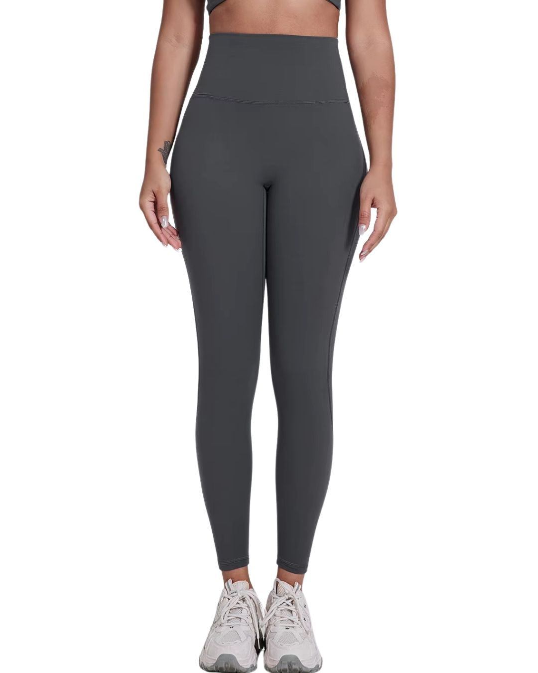 Woman wearing charcoal gray ultra high rise ORU Legacy Leggings with no front seam and butterfly 3-seam waistband detail.