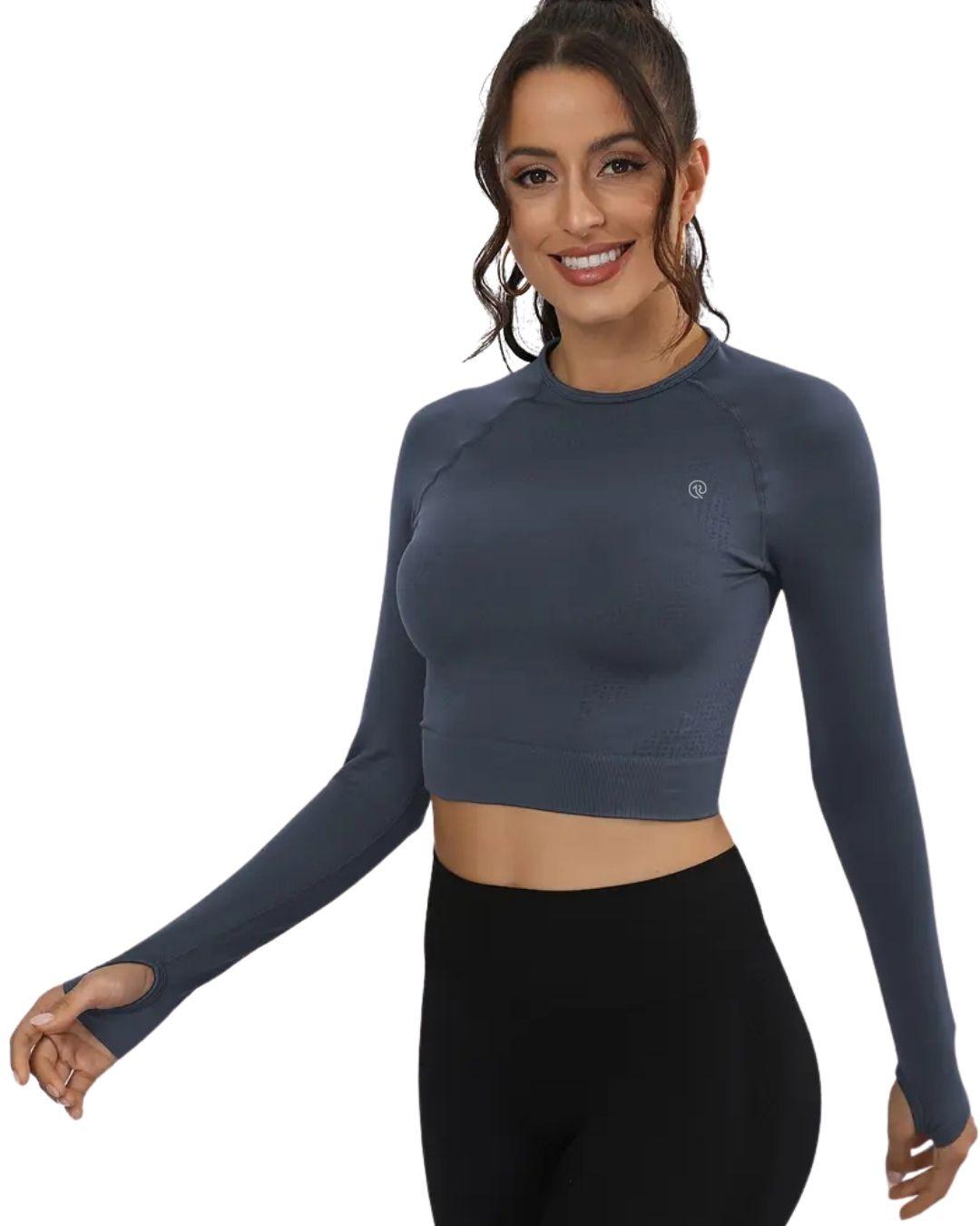 Woman wearing blue slim fit ORU cropped long sleeve top with thumb hole cuffs and crew neck