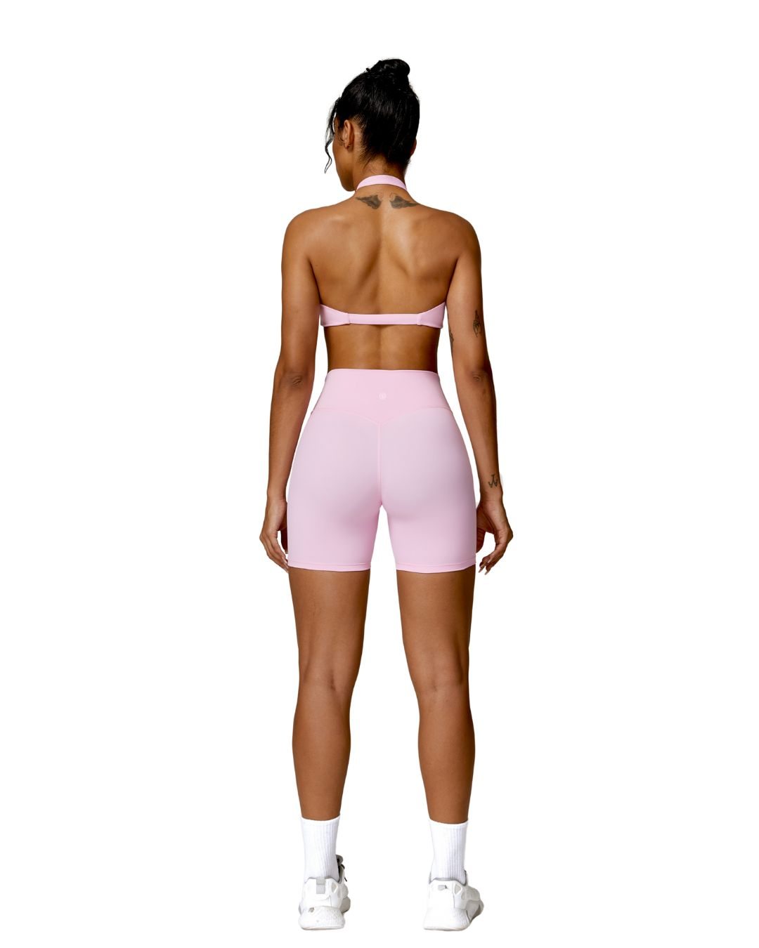 Woman wearing pink ORU MIKA SHORT with V-shaped back design, breathable and quick-dry fabric, ideal for gym and yoga.