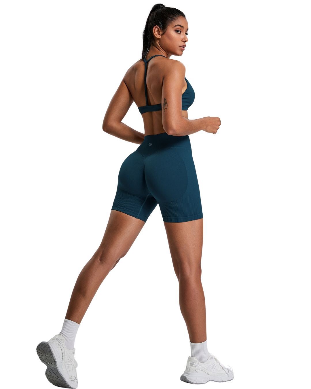 Athletic woman wearing ORU Elura sports bra with T-shape back and matching shorts
