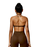 woman wearing brown oru mika halter sports bra with halter neck support and matching high-waisted leggings seen from back