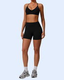 Woman wearing black ORU Phul Shorts with mid-rise waist and elasticated waistband for comfort and curve-enhancing scrunch detail