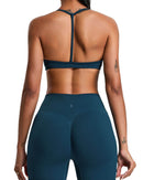 Back view of a woman wearing a navy ORU ELURA SPORTS BRA with a T-shape back and matching leggings.