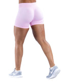 Woman wearing pink high-stretch seamless impact shorts showing subtle glute contour and durable fabric