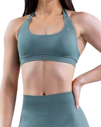 Woman wearing a teal Impact Sports Bra showing medium support and durable fabric.