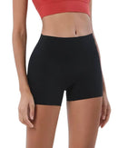 Woman wearing black ORU Mid-Rise Yoga Shorts with slim fit and subtle glute contour.