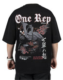 Back view of a black duality oversized tee with graphic print featuring a samurai mask and flames, worn by a model.