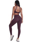Woman wearing ultra high rise maroon ORU Legacy Leggings with butterfly 3-seam back waistband and no front rise seam.