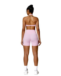 Woman wearing pink ORU MIKA SHORT with V-shaped back design, breathable and quick-dry fabric, ideal for gym and yoga.