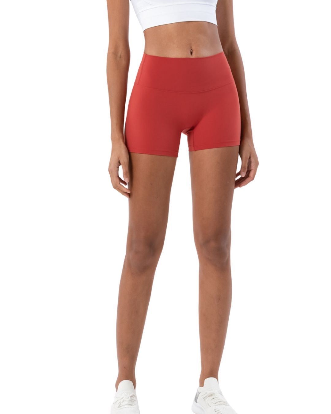 Woman wearing ORU mid-rise yoga shorts in red with slim fit and high stretch fabric