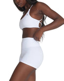 Woman wearing white ORU CROSSOVER SPORTS BRA with seamless design and strappy back