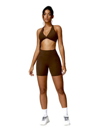 Woman wearing brown ORU MIKA SHORTs with V-shaped back design, breathable and quick-dry fabric, ideal for gym and yoga.