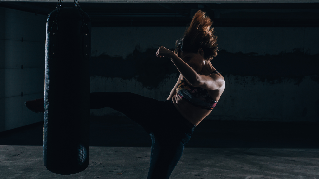 Person practicing martial arts in a dark indoor setting